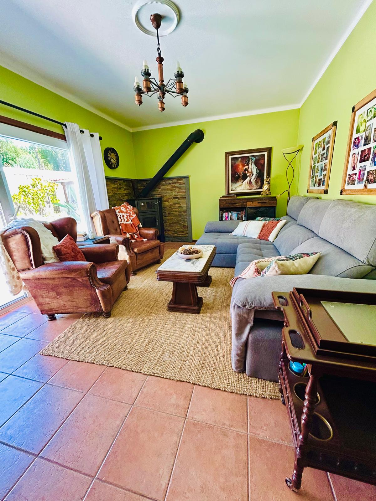 Cozy den with wood-burning stove, sofa and armchairs at Sunrise Villa Alvorada