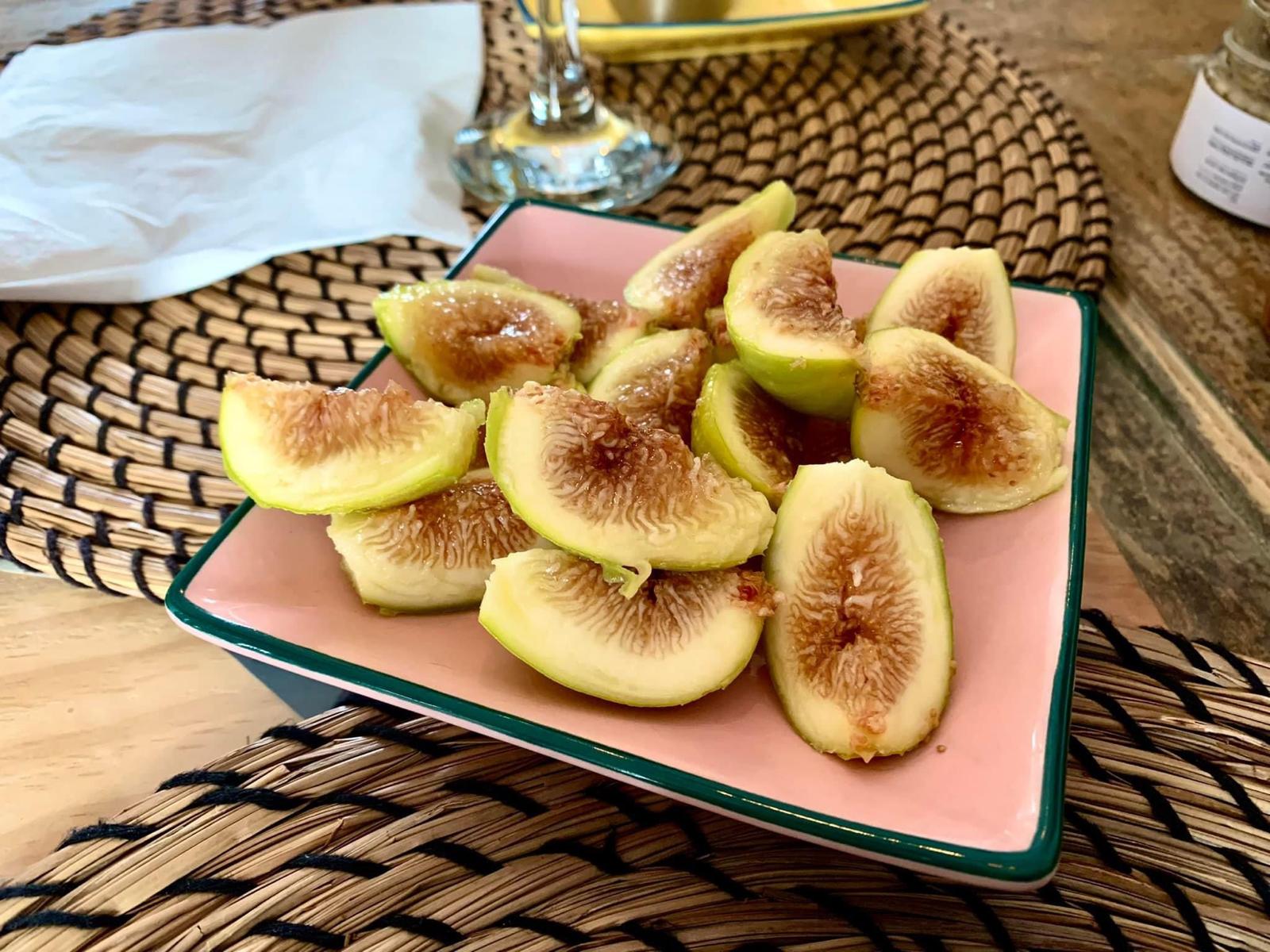 Sliced fresh figs on a pink plate revealing their honeyed pink centres