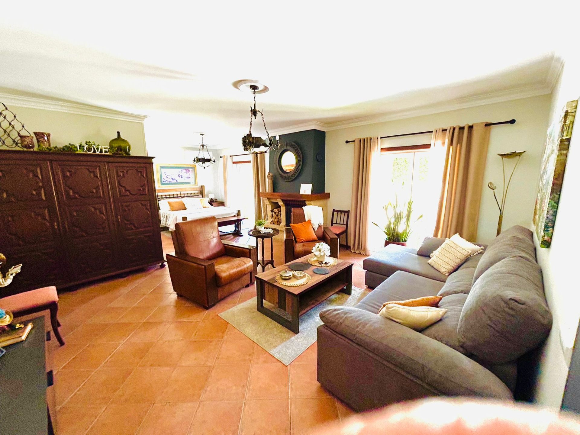 Sun-Kissed Suite sitting area with sofa, leather armchairs and view through to the bedroom