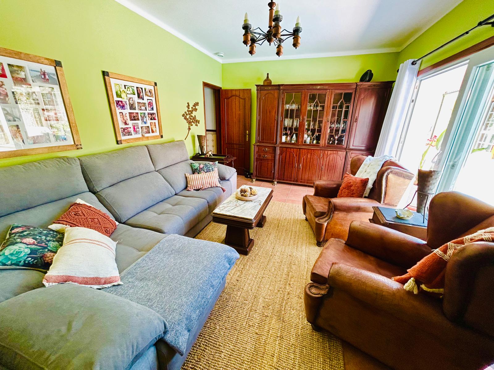 Den sitting area with vintage cabinet and comfortable seating at Sunrise Villa Alvorada